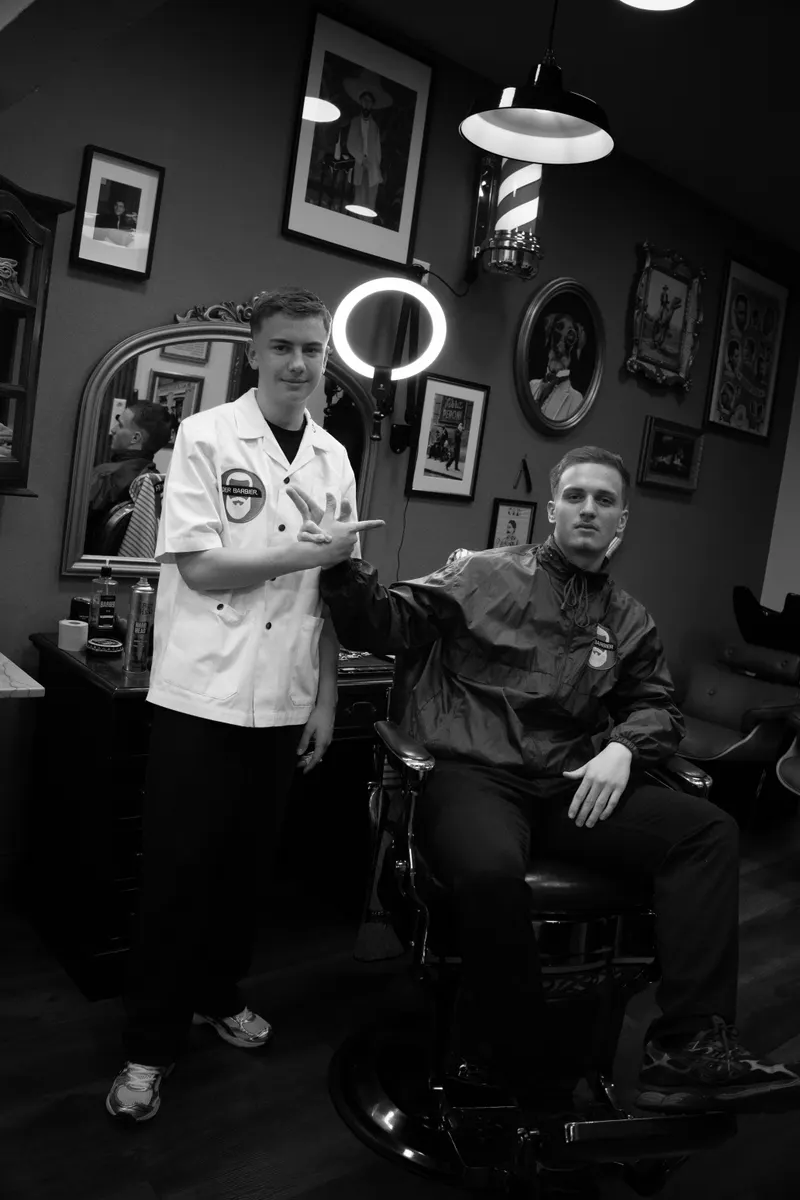 Barbier und Kunde vor dem Spiegel mit Ringlicht
