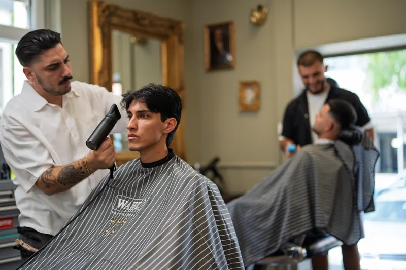 Zwei Friseure von Der Barbier arbeiten parallel an ihren Kunden in Weil am Rhein